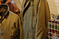 Groene tweed jassen hangend in de winkel naast decoratieve blikken